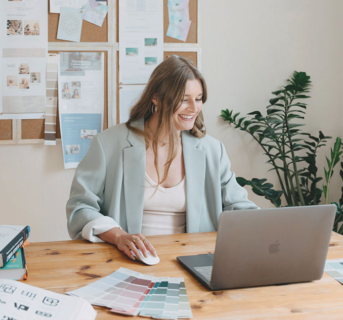 Webdesignerin Katharina Rother-Schönfeld mit Freude am Schreibtisch bei der Entwicklung einer Website